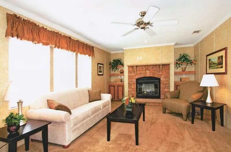 Living room with a fireplace, ceiling fan and a cream sofa